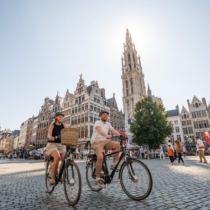 Cyclists at the Grote Markt in Antwerp in front of Flemish gabled houses and the tower of the Cathedral of Our Lady. | © Piet de Kersgieter – Antwerp Grote Markt