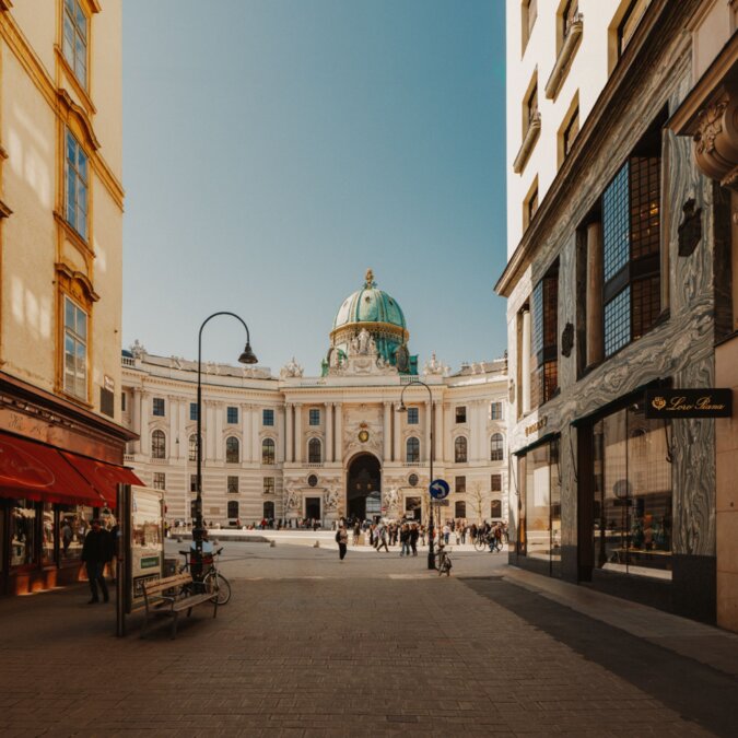 View of Vienna’s Hofburg through a historic street | © Wien Tourismus