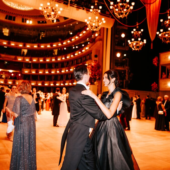 De nombreux couples dansent la valse dans une salle décorée pour l'occasion et vêtus de tenues de fête.  | © Wien  Tourismus | Paul Bauer