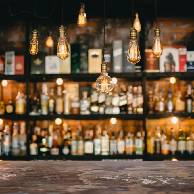 Metal table and vintage lamps with a liqueur bar background | © Shutterstock 1671936808