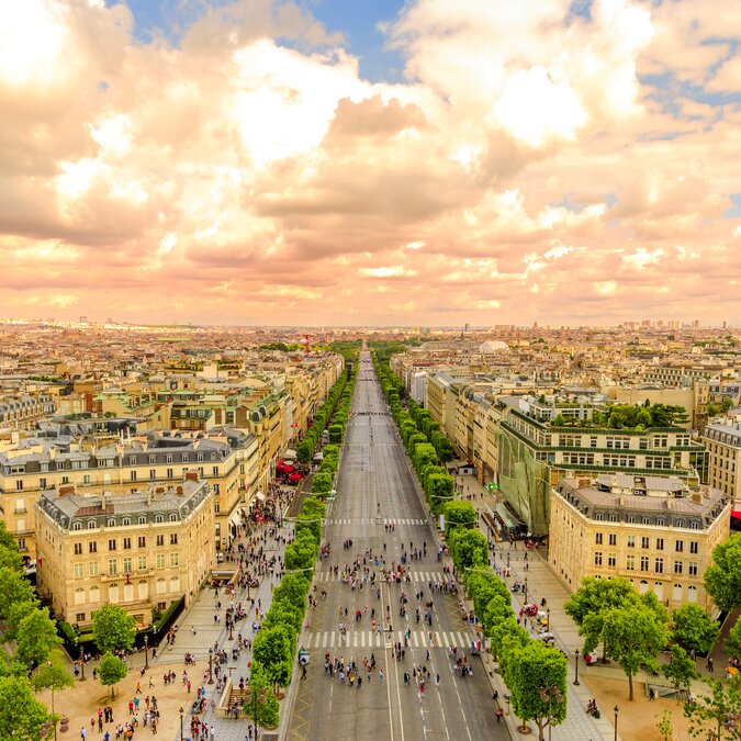 Vue aérienne de la ligne d'horizon de Paris depuis l'Arc de Triomphe au coucher du soleil. Arc de triomphe de la place Charles de Gaulle avec l'avenue des Champs Elysées sans voitures | © Shutterstock 1947099166
