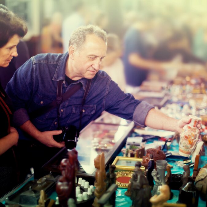 Un couple de touristes enjoués étudie la gamme du marché aux puces. | © Shutterstock 1334550560