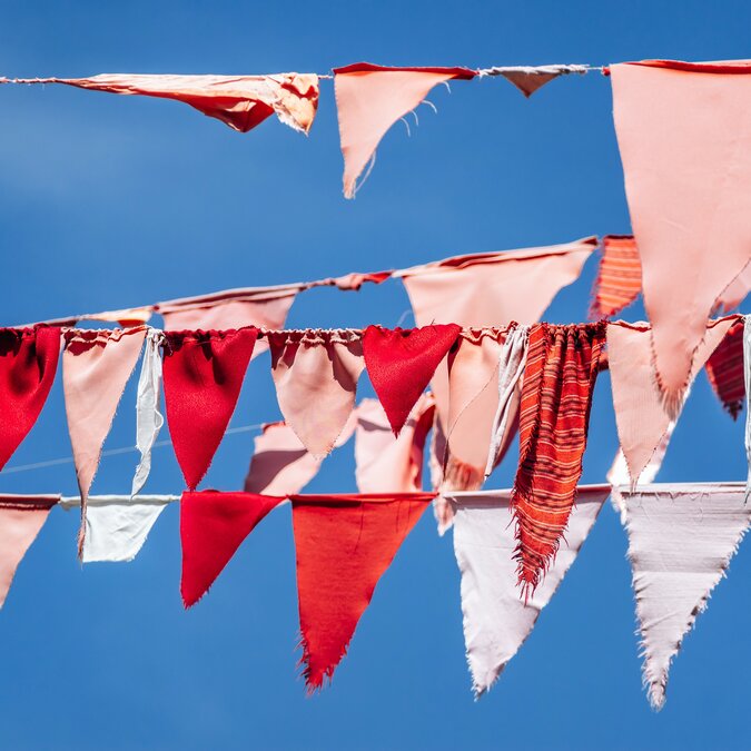 Colourful pennants on a line in the wind | © shutterstock / 2602576667