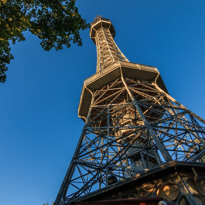Old Petrin radio tower made of steel in Prague on the Petrin hill with view from the pedestal in the district Lesser Town with observation deck in the sunshine and blue sky | © Shutterstock 1534129550